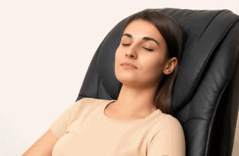 Kvinde sidder roligt i en massagestol med lukkede øjne for at illustrere afslapning og mindre angst.